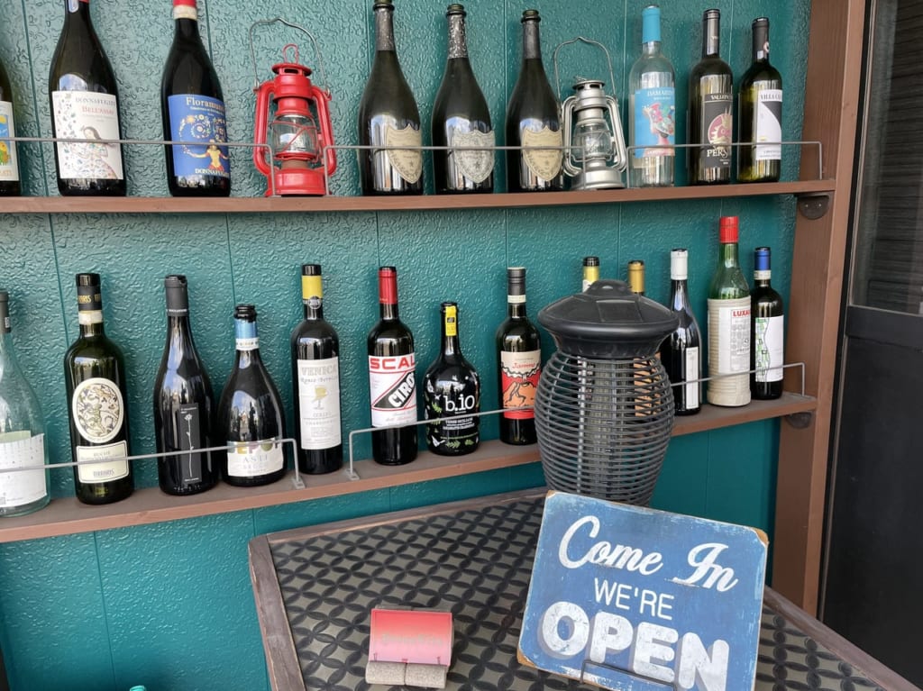 オステリアボナビータの店頭にある空のワインボトル